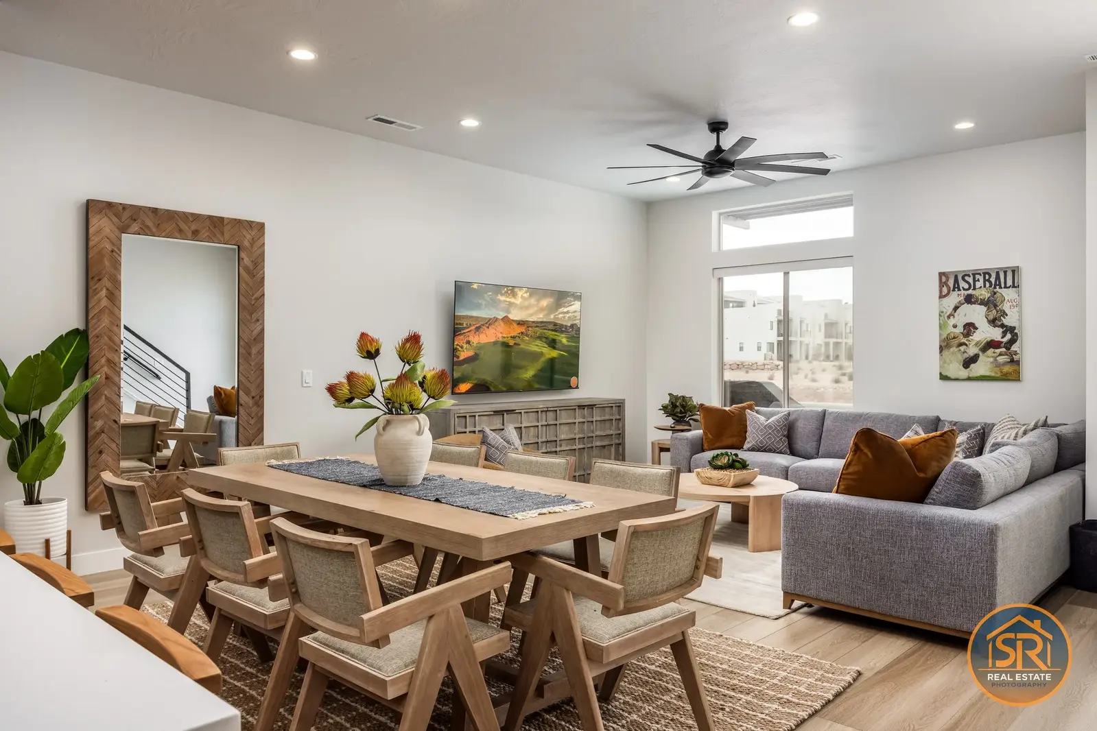 Open dining and living area with a wooden dining table and gray sofa.