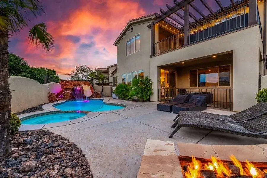 Illuminated home and pool beneath an orange twilight sky photographed by Sam Reed